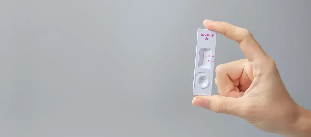 Close up of hand holding a piece of an at-home rapid COVID test